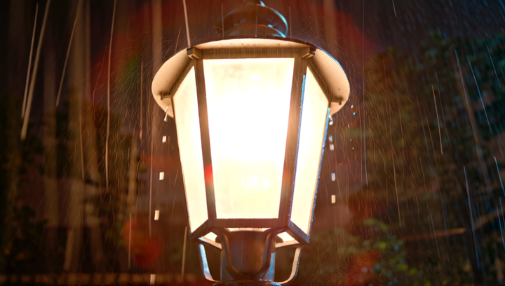 Tight shot of a Gotham streetlight in the rain